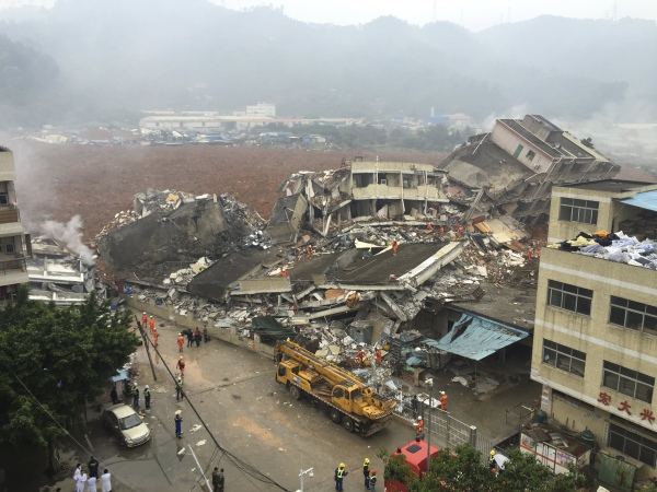 Damaged buildings are seen as rescuers search for survivors after a landslide hit an industrial park in Shenzhen, Guangdong province, China, December 20, 2015. REUTERS/China Daily ATTENTION EDITORS - THIS PICTURE WAS PROVIDED BY A THIRD PARTY. THIS PICTURE IS DISTRIBUTED EXACTLY AS RECEIVED BY REUTERS, AS A SERVICE TO CLIENTS. CHINA OUT. NO COMMERCIAL OR EDITORIAL SALES IN CHINA. TPX IMAGES OF THE DAY