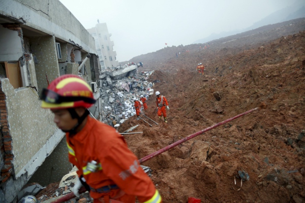 Firefighters search for survivors near a damaged building at the site of a landslide at an industrial park in Shenzhen, Guangzhou, China, December 20, 2015. REUTERS/Tyrone Siu TPX IMAGES OF THE DAY