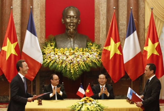 Jetstar Pacific CEO Le Hong Ha (R) and Airbus Commercial CEO Fabrice Bregier (L) prepare to exchange signed contracts as France's President Francois Hollande (2nd L) and Vietnam's President Tran Dai Quang (2nd R) applaud during a signing ceremony at the Presidential Palace in Hanoi on September 6, 2016. Hollande is in France's former colony Vietnam to meet political and business leaders in a bid to boost ties with one of southeast Asia's fastest growing economies. / AFP PHOTO / POOL / KHAM