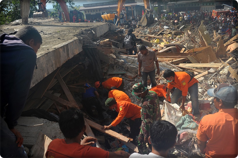 Members of a search and rescue team look for earthquake survivors trapped in rubble in Pidie Jaya, Aceh province on December 7, 2016.  The death toll from a strong 6.5-magnitude earthquake that struck Indonesia's Aceh province on December 7 has nearly doubled to 97, a military chief said. / AFP PHOTO / CHAIDEER MAHYUDDIN